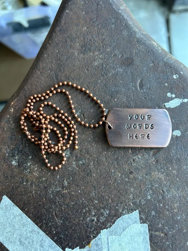 A copper-coloured hand-stamped tag