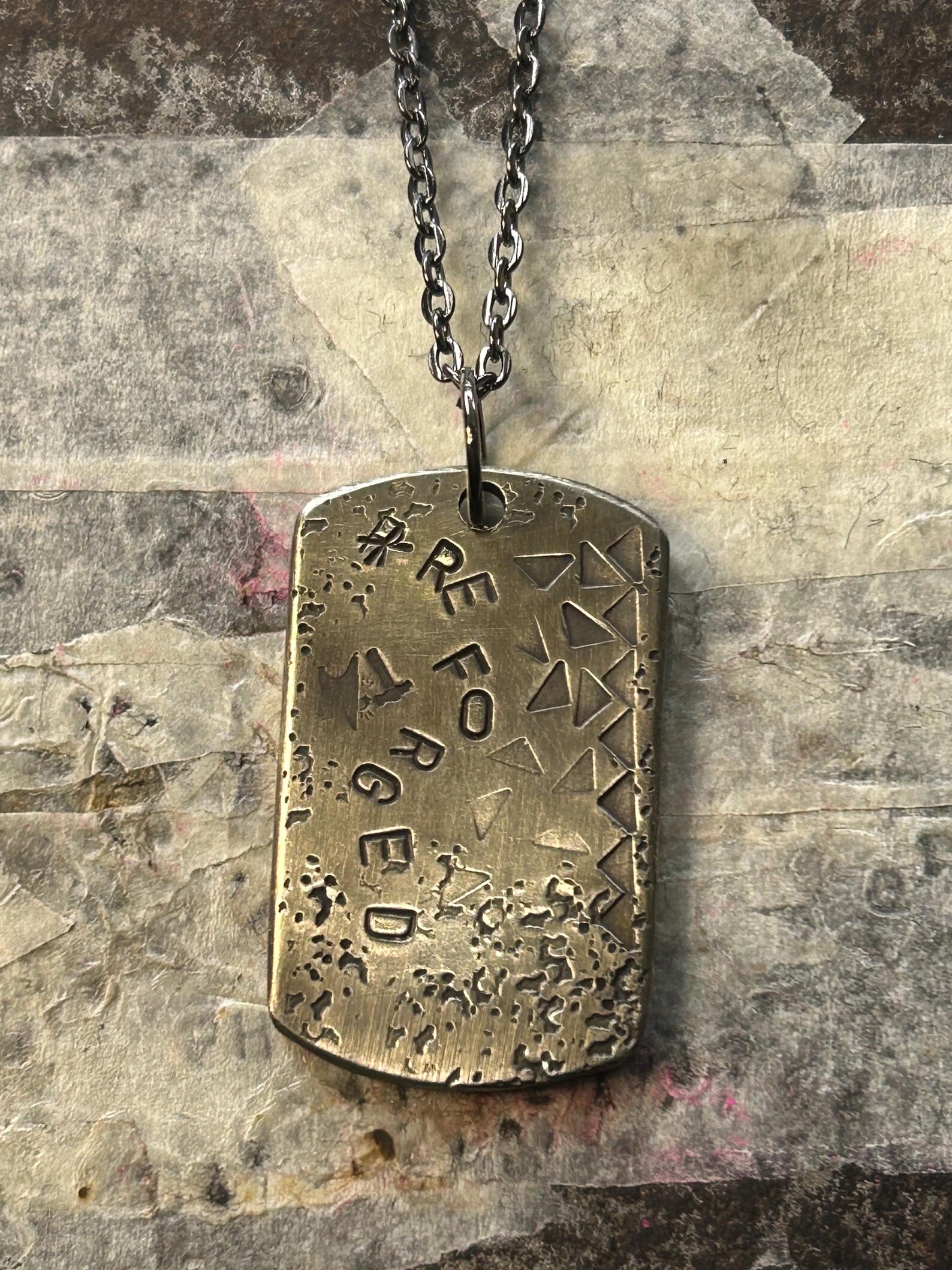 KJ’s Reforged hand-stamped pendant, photographed for its Etsy listing