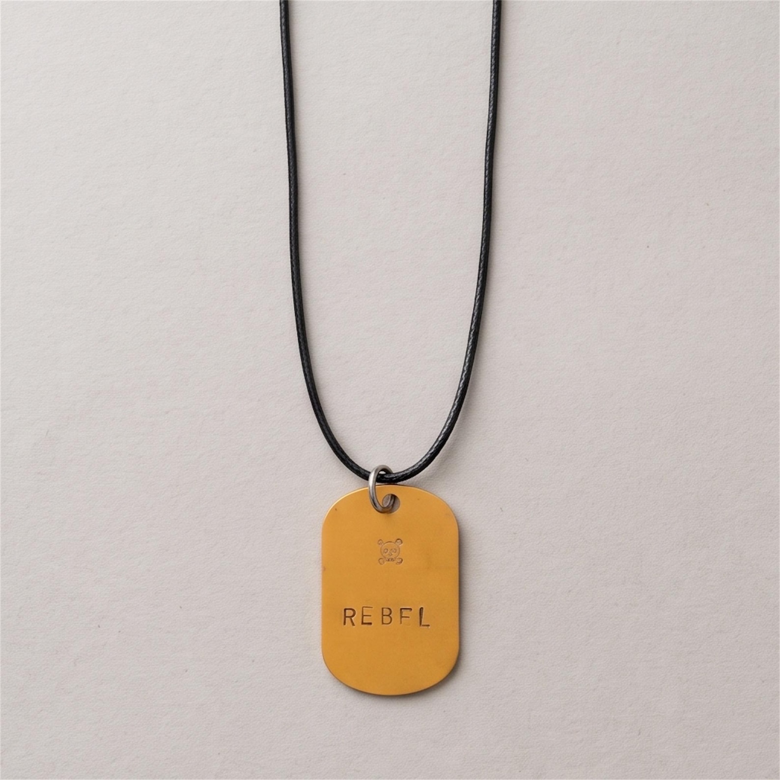 Hand-stamped REBEL kids dog tag necklaces in gold and blue aluminium